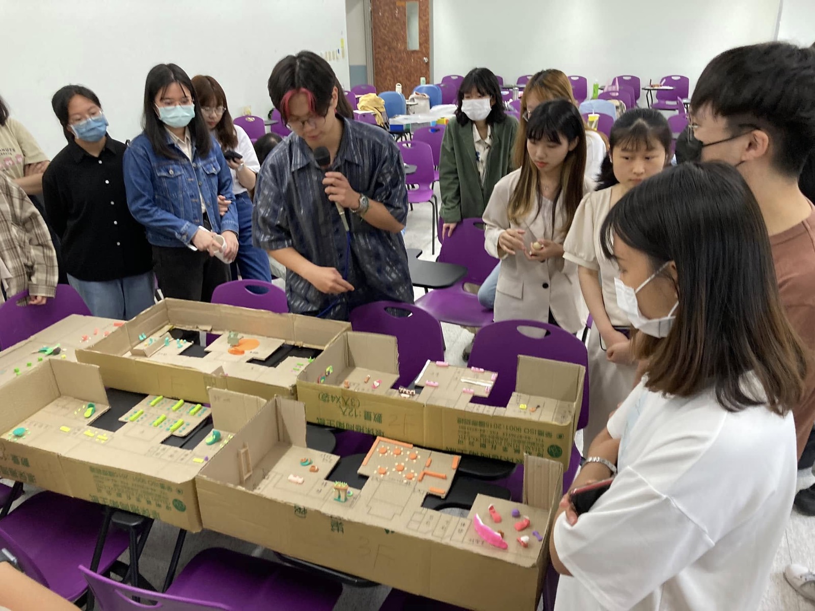 Stakeholders gathered around the 1:1 cardboard building model
